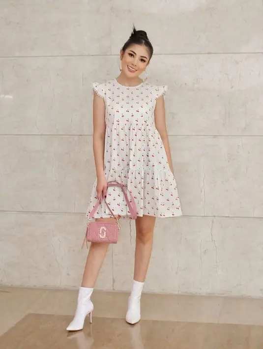 Gaya penampilan Nindy Ayunda sendiri terbilang stylish. Menggunakan simple dress berwarna putih dengan motif ceri serta tatanan rambut dan riasan sederhan, penampilan Nindy ini pun tetap banjir pujian netizen. (Liputan6.com/IG/@nindyayunda)