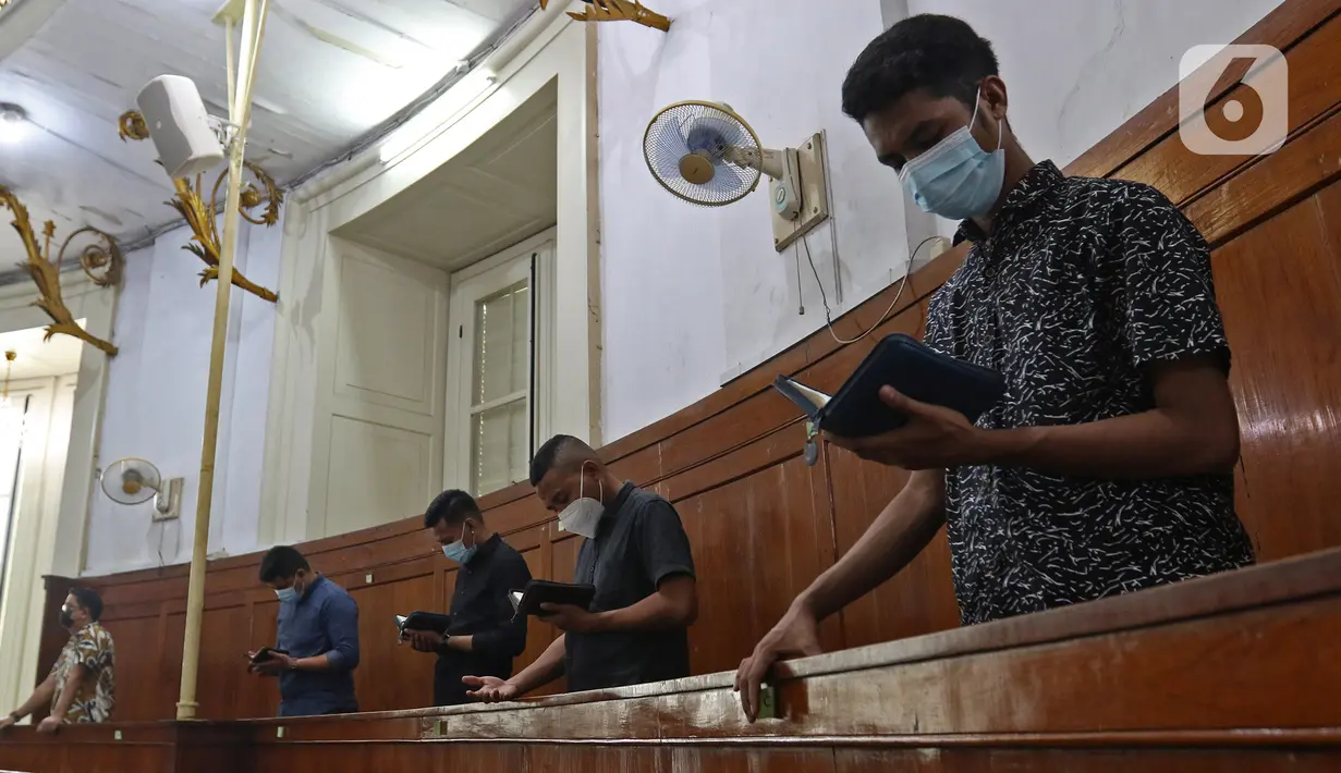 Umat Kristiani melakukan prosesi ibadah misa Jumat Agung pada rangkaian Hari Raya Paskah di Gereja Immanuel, Jakarta, Jumat (2/4/2021). Dalam suasana pandemi, misa Jumat Agung diselenggarakan dengan memberlakukan pembatasan kedatangan jemaat serta secara daring. (Liputan6.com/Herman Zakharia)