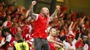 Sorang suporter Denmark dengan menggebu-gebu merayakan kesuksesan Tim Dinamit yang secara dramatis lolos ke babak 16 besar Euro 2020. (Jonathan Nackstrand/Pool via AP)