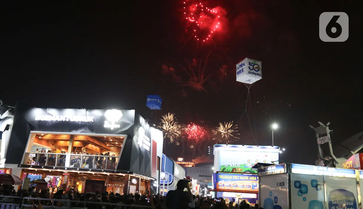 Pengunjung menyaksikan pesta kembang api di langit saat Jakarta Fair ke-53 atau Pekan Raya Jakarta (PRJ) di JiExpo Kemayoran, Jakarta Pusat, Selasa (21/6/2022) malam. Pesta kembang api menggelegar di kawasan PRJ bertepatan dengan HUT Jakarta yang jatuh pada besok, 22 Juni 2022. (Liputan6.com/Herman Zakharia)