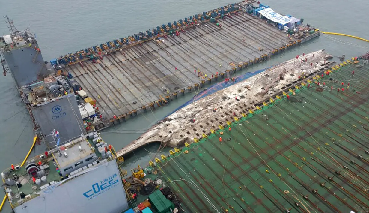 Bangkai kapal feri Sewol yang tenggelam hampir tiga tahun lalu dan menewaskan 304 orang, muncul ke permukaan, di pulau barat daya Jindo, Korea Selatan, Kamis (23/3). Upaya pengangkatan telah berlangsung sejak Rabu kemarin. (Park Gyung-woo/Hankookilbo/AP)