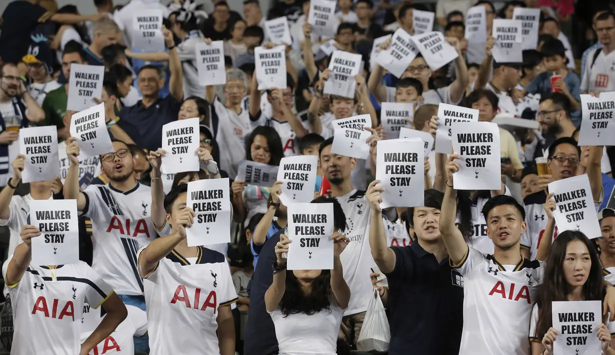 Fans Tottenham Hotspur memegang kertas bertuliskan permohonan untuk Kyle Walker tetap bertahan saat laga melawan Kitchee SC di  di Hong Kong, (26/5/2017). Tottenham menang 4-1. (AP/Kin Cheung)