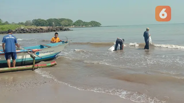 Warga Pungut Sampah Plastik Di Pantai Dan Nelayan Persiapkan Perahu Untuk Mencari Ikan Di Anyer, Kabupaten Serang, Banten. (Kamis, 30/06/2022). (Liputan6.com/Yandhi Deslatama).