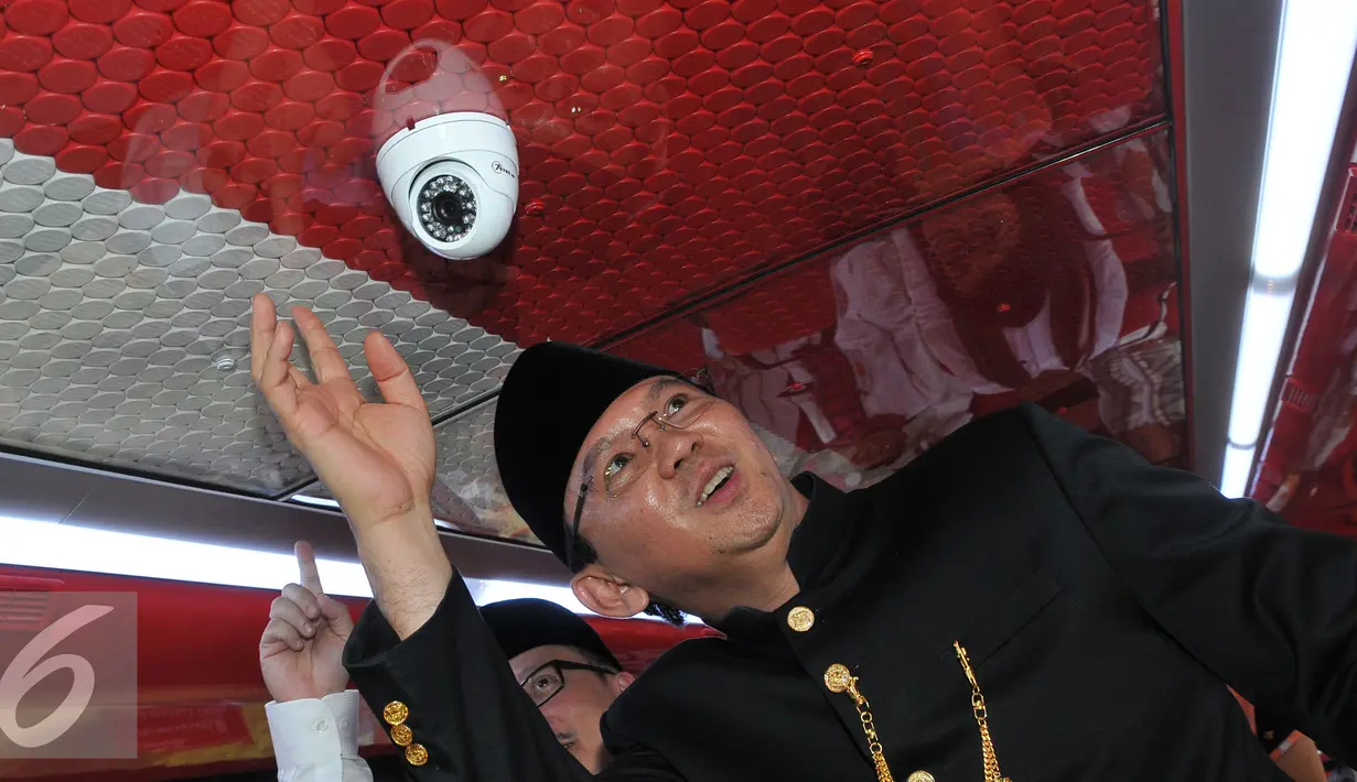 Basuki T Purnama melihat isi di dalam bus saat peluncuran bus-bus baru dan hotline Transjakarta di monas, Jakarta, Senin (22/6/2015). Sebanyak 20 unit bus gandeng Transjakarta buatan eropa resmi diluncurkan. (Liputan6.com/Herman Zakharia)