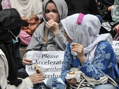 Pencari suaka asal Afghanistan membawa poster tuntutan di depan Kantor UNHCR, Jakarta, Senin (15/11/2021).  Ratusan pencari suaka tersebut menuntut segera dipindahkan ke negara ketiga yang terbebas dari konflik perang setelah lebih 10 tahun mengungsi di Indonesia. (merdeka.com/Iqbal S Nugroho)