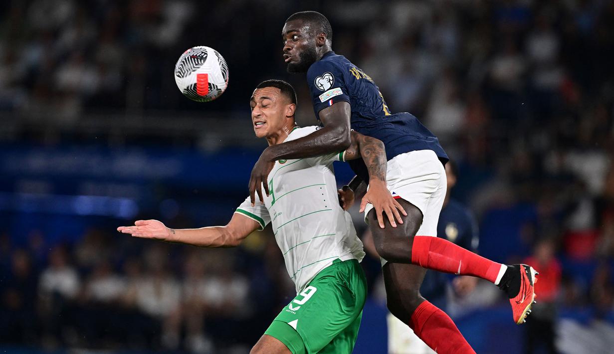 Bek Timnas Prancis, Dayot Upamecano (kanan) berduel udara dengan striker Republik Irlandia, Adam Idah pada laga Grup B Kualifikasi Euro 2024 di Parc des Princes Stadium, Paris, Jumat (8/9/2023) dini hari WIB. (AFP/Miguel Medina)
