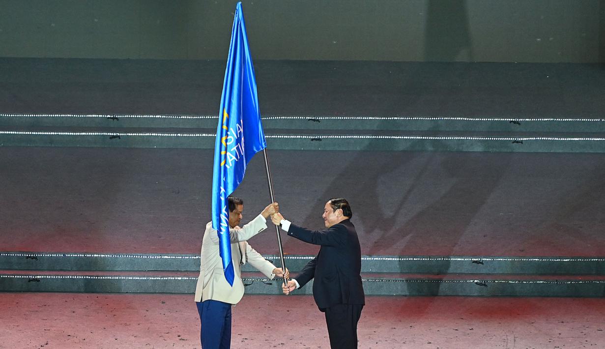 National Olympic Committee (NOC) Vietnam lalu menyerahkan bendera ASEAN kepada NOC Kamboja yang akan menjadi tuan rumah SEA Games pada 2022. Panitia penyelenggara SEA Games 2021 (VIESGOC) lalu menyerahkan tongkat estafet pesta olahraga ASEAN ke Kamboja yang akan menjadi tuan rumah pada 2023. (AFP/Tang Chhin Sothy)