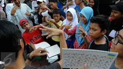 Anak-anak ikut berlatih bahasa isyarat saat sosialisasi di Car Free Day (CFD), Jakarta, Minggu (11/9). Sosialisasi belajar bahasa isyarat untuk mengkampanyekan penggunaan bahasa isyarat dalam dialog para penyandang tuna rungu. (Liputan6.com/Faizal Fanani)
