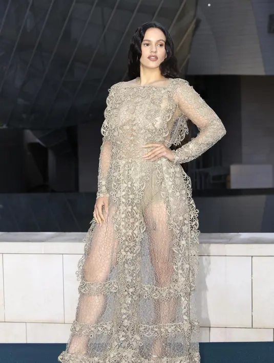 Rosalia mengenakan gaun rajut emas bersulam dari Dior Cruise 2025 dengan pakaian dalam Dior. Ia juga mengenakan sepatu Dior. [Dior]