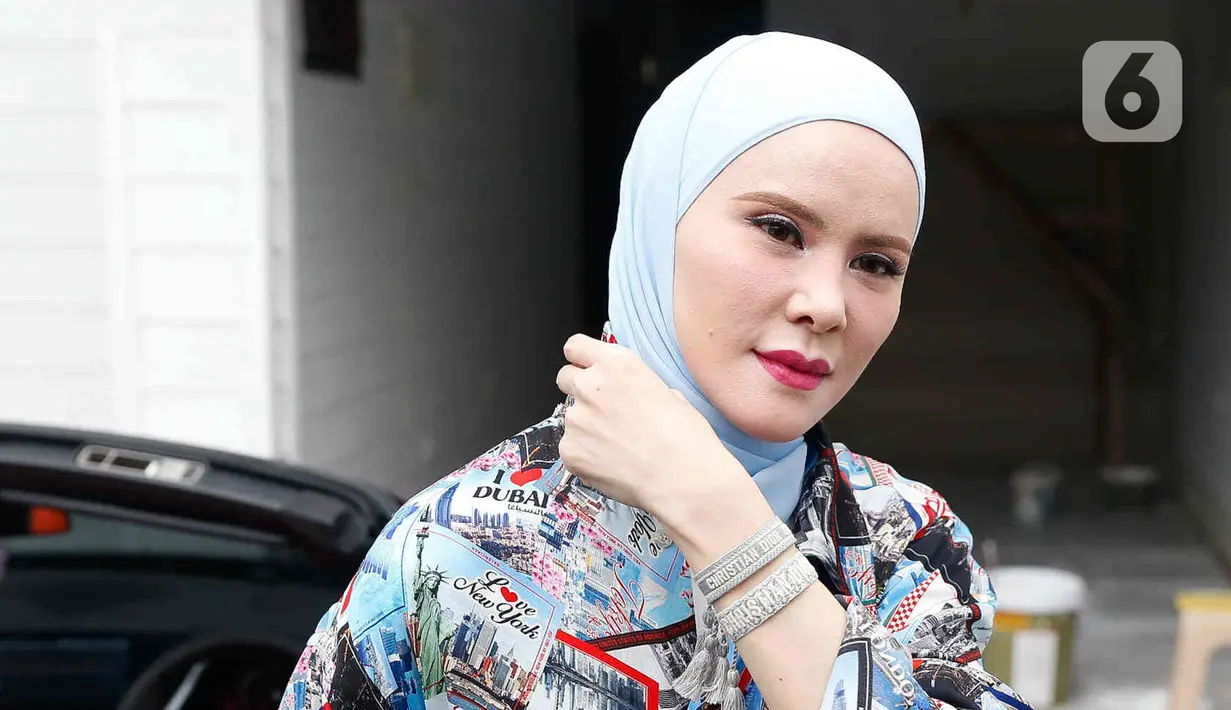 Aktris Angel Lelga turun dari kendaraannya di kediamannya di kawasan Jagakarsa, Jakarta, Rabu (6/7/2022). Tubuh Angel Lelga yang mungil, tinggi, dan kulit putih semakin sempurna dengan balutan hijab. (Liputan6.com/Herman Zakharia)