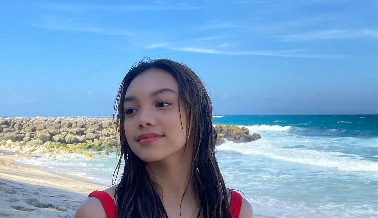 Berenang di pantai, Naura mengenakan swimsuit polos warna merah. (Instagram/naura.ayu).