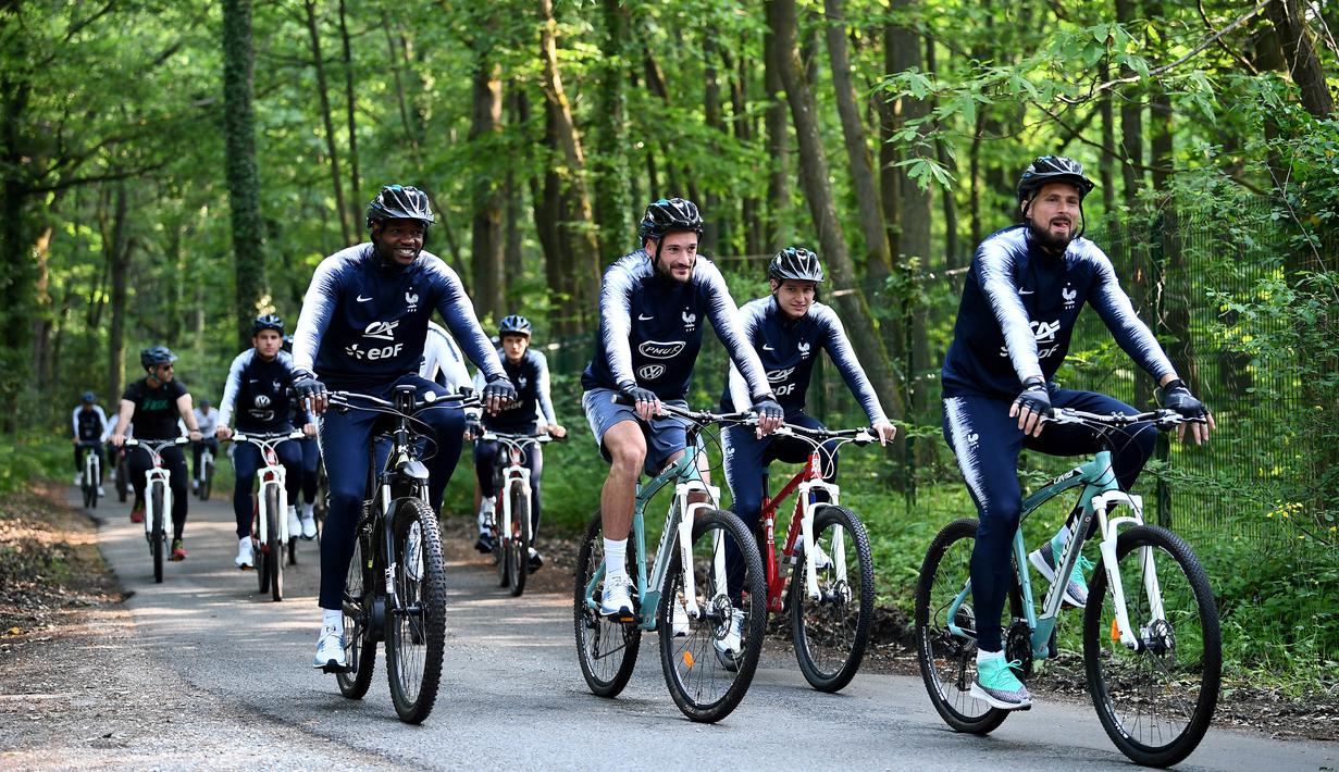 Para pemain Prancis bersepeda di sekitar markas latihan Les Blues di Clairefontaine, Rabu (23/5/2018). Bersepeda merupakan salah satu menu latihan untuk meningkatan kebugaran jelang Piala Dunia 2018. (AFP/Franck Fife)