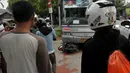 Sejumlah warga menyaksikan evakuasi sepeda motor yang tertabrak Bus Transjakarta di kawasan permata hijau, Jakarta, Jumat (27/3/2015). Sejumlah warga sedang melakukan evakuasi speda motor yang berada di dalam bus transjakarta. (Liputan6.com/Johan Tallo)