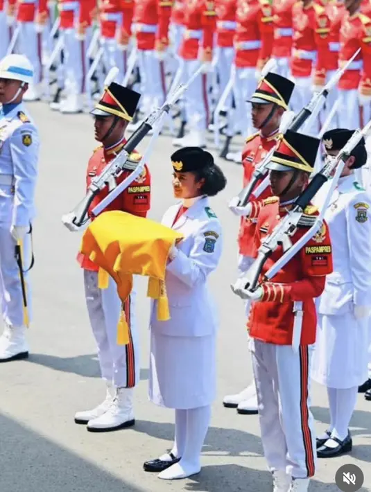Bak Cinderella, sepatu Lilly tiba-tiba copot usai membawa bendera ke tengah lapangan dan hendak menghadap Presiden Jokowi. Alhasil ia menghadap Jokowi dengan membawa baki tanpa sepatu di kaki kirinya. Ia pun harus berjalan kembali mengelilingi lapangan upacara tanpa sepatu, namun ia profesional tetap bersikap tenang. [Instagram/Jokowi]