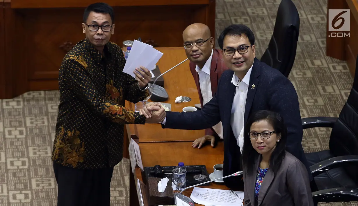 Calon Pimpinan KPK Nawawi Pomolango (kiri) berjabat tangan dengan Ketua Komisi III DPR Aziz Syamsuddin (kanan) usai menerima amplop berisi tema makalah yang harus dibuat, saat uji kelayakan dan kepatutan capim KPK di Kompleks Parlemen, Senayan, Jakarta, Senin (9/9/2019). (Liputan6.com/Johan Tallo)