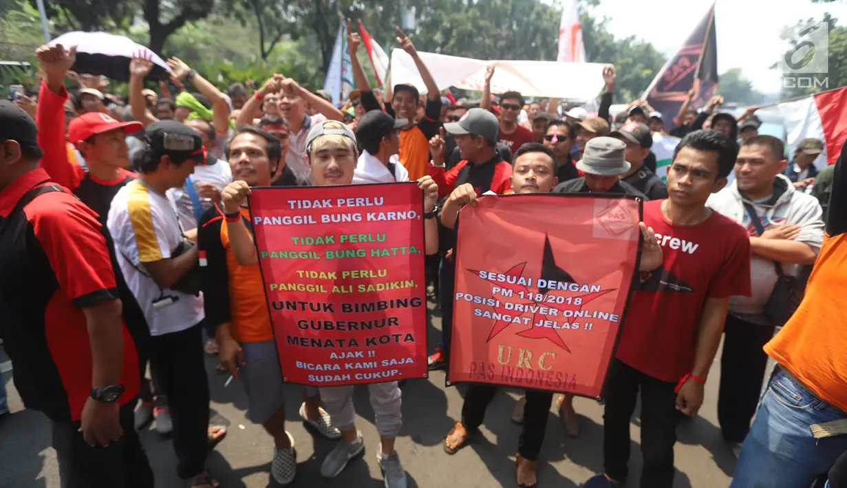 Puluhan sopir taksi online membawa poster dalam unjuk rasa di depan Balai Kota Jakarta, Senin (19/8/2019). Mereka meminta Gubernur DKI Jakarta Anies Baswedan agar angkutan sewa khusus atau taksi online untuk bebas dari kebijakan perluasan ganjil genap. (Liputan6.com/Angga Yuniar)