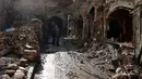 Dua orang pria melihat kondisi bangunan pasar lama di kota tua Aleppo, Suriah (18/1). Perang di Aleppo telah mereda lebih dari setahun yang lalu, namun kondisi bangunan di pasar ini masih belum pulih. (AP Photo/Hassan Ammar)