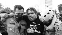 Pegiat media sosial Ade Armando saat diamankan pihak kepolisian dari amukan massa di depan Gedung DPR RI, Senin (11/4/2022). (FOTO: Dok. Liputan6.com)