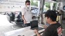 Petugas melayani pengunjung yang menjalani uji emisi mobilnya di IRTI Monas, Jakarta, Rabu (15/2/2023). Mobil yang telah lolos uji emisi akan dikenakan tarif parkir sebesar Rp 4.000 per jam, sedangkan yang belum lolos dikenakan tarif sebesar Rp 7.500. (merdeka.com/Iqbal S. Nugroho)