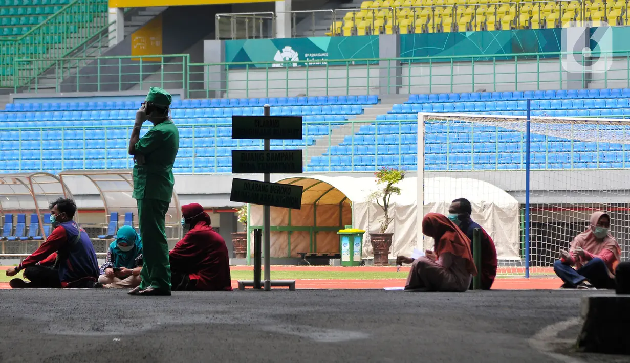Tenaga medis menerapkan kebijakan pengaturan jarak saat menunggu rapid test pendektesian COVID-19 di Stadion Patriot Candrabhaga, Bekasi, Rabu (25/3/2020). Pemeriksaan hanya diperuntukan bagi tenaga medis seluruh puskesmas, dan rumah sakit yang ada di Kota Bekasi. (Liputan6.com/Herman Zakharia)