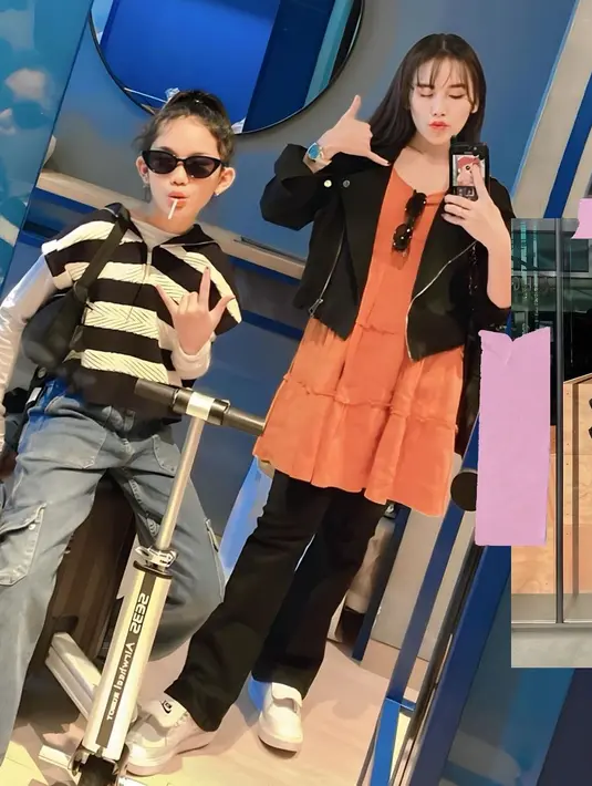 Diketahui keduanya sering bepergian bersama. Lihat gaya Ayu Ting Ting yang mengambil potret mirror selfie. Ia mengenakan dress oranye yang dipadu cropped jacket dan celana panjang hitam. Sedangkan Bilqis tampil slay dengan manset putih yang ditumpuk dengan jaket hoodie lengan pendek bermotif garis hitam-putih, dipadu cargo denim pants, dan sunglasses. [Foto: Instagram/ayutingting92]