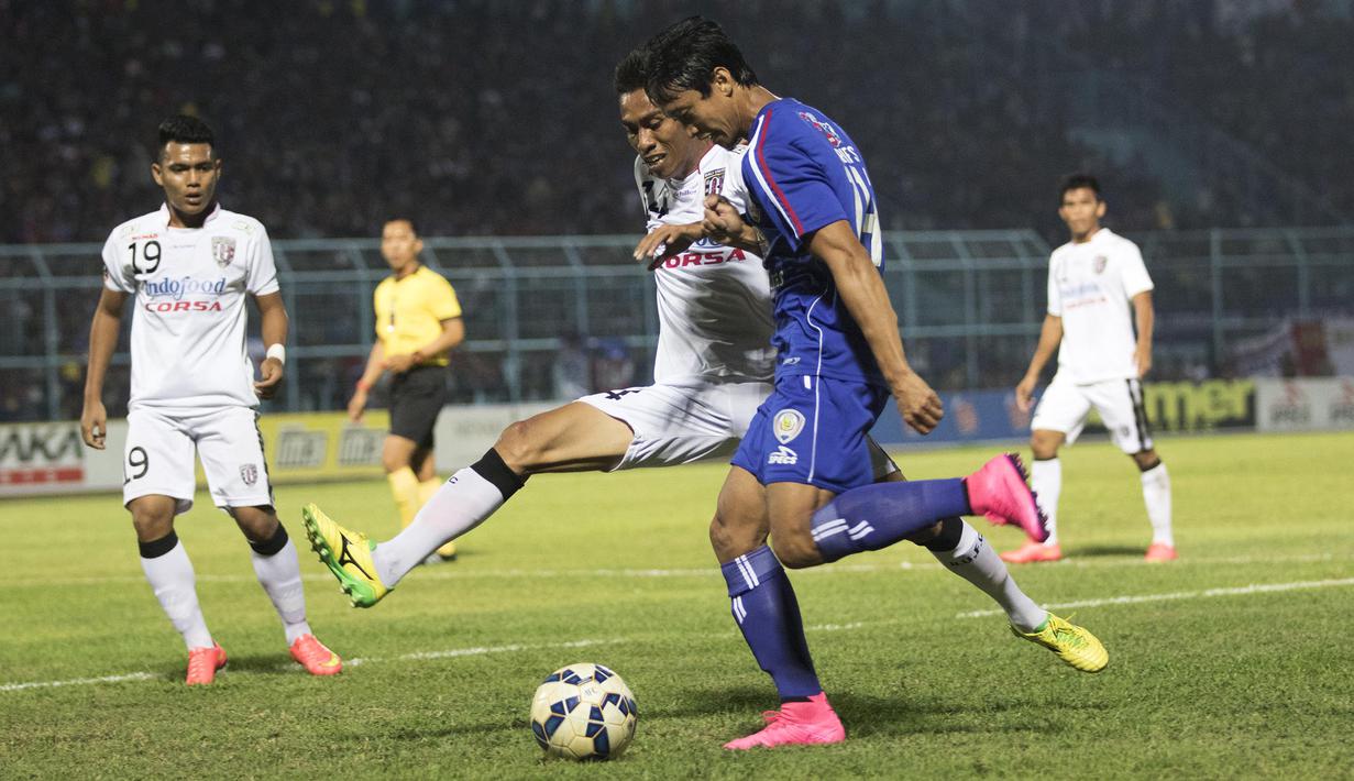 Pemain Arema Cronus, Arif Suyono berusaha melewati hadangan pemain Bali United, Fadil Sausu pada laga perempat final Piala Presiden di Stadion Kanjuruhan, Malang, Sabtu (19/9/2015). (Bola.com/Vitalis Yogi Trisna)