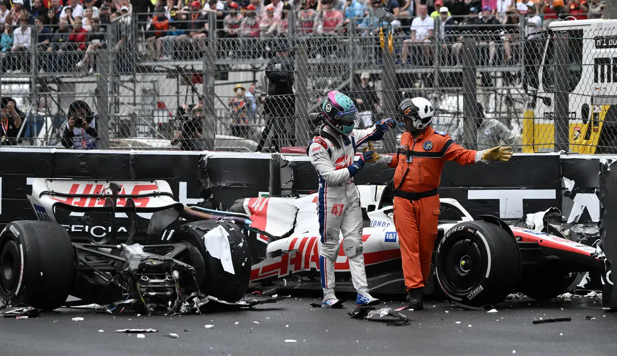 Pembalap Tim Haas, Mick Schumacher dibantu oleh marshall meninggalkan mobilnya usai mengalami kecelakaan saat Formula 1 GP Monako yang berlangsung di Circuit de Monaco, Minggu, 29 Mei 2022. (AFP/Loic Venance)