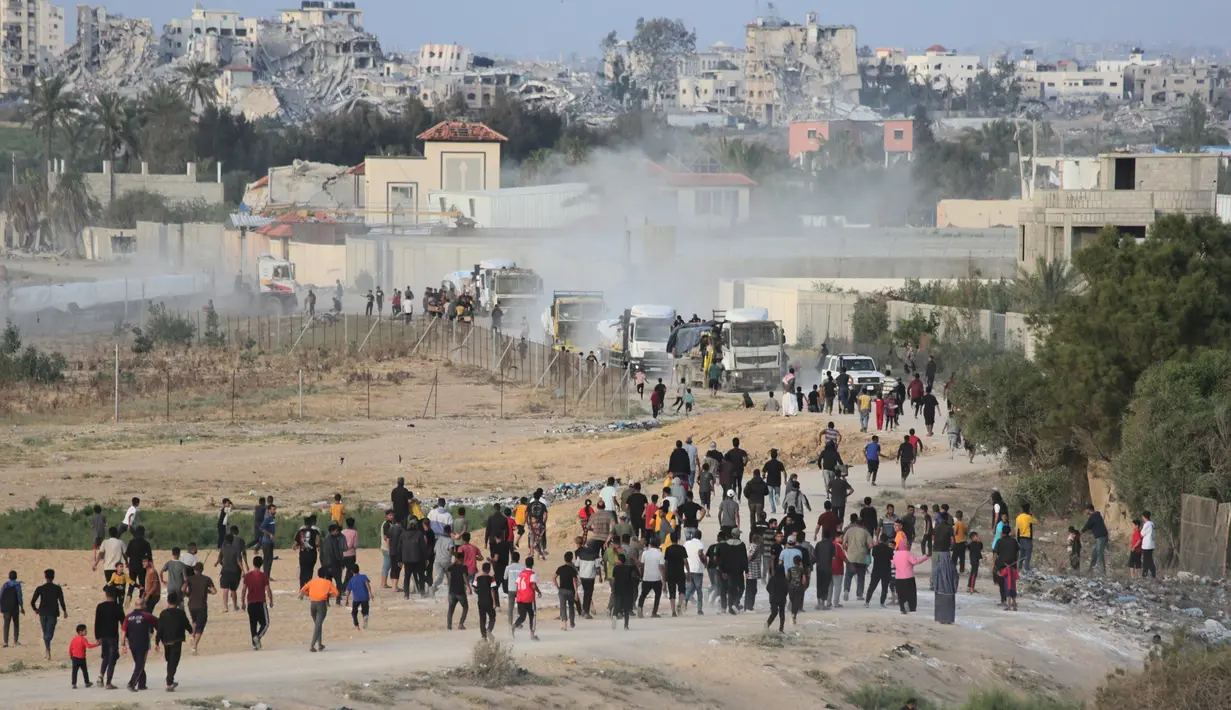 Warga Palestina membongkar paksa truk berisi bantuan kemanusiaan yang keluar dari Dermaga Trisula yang dibangun oleh Amerika Serikat. (Foto: AFP)