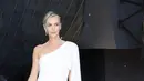 Charlize Theron mengenakan gaun sutra putih Dior Haute Couture dengan tas dan sepatu Dior. Ia juga mengenakan cincin Bois de Rose dan Rose Dior Bagatelle serta anting dan gelang Couture Dior berbahan emas putih dan berlian dari Dior Joaillerie.  [Dior]