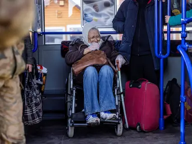 Reaksi lansia di kursi roda di bus menuju Przemysl setelah melintasi perbatasan Ukraina-Polandia di perbatasan Medyka, Polandia, 17 Maret 2022. Lebih dari tiga juta warga Ukraina telah melarikan diri melintasi perbatasan, kebanyakan perempuan dan anak-anak, menurut PBB. (Wojtek RADWANSKI/AFP)