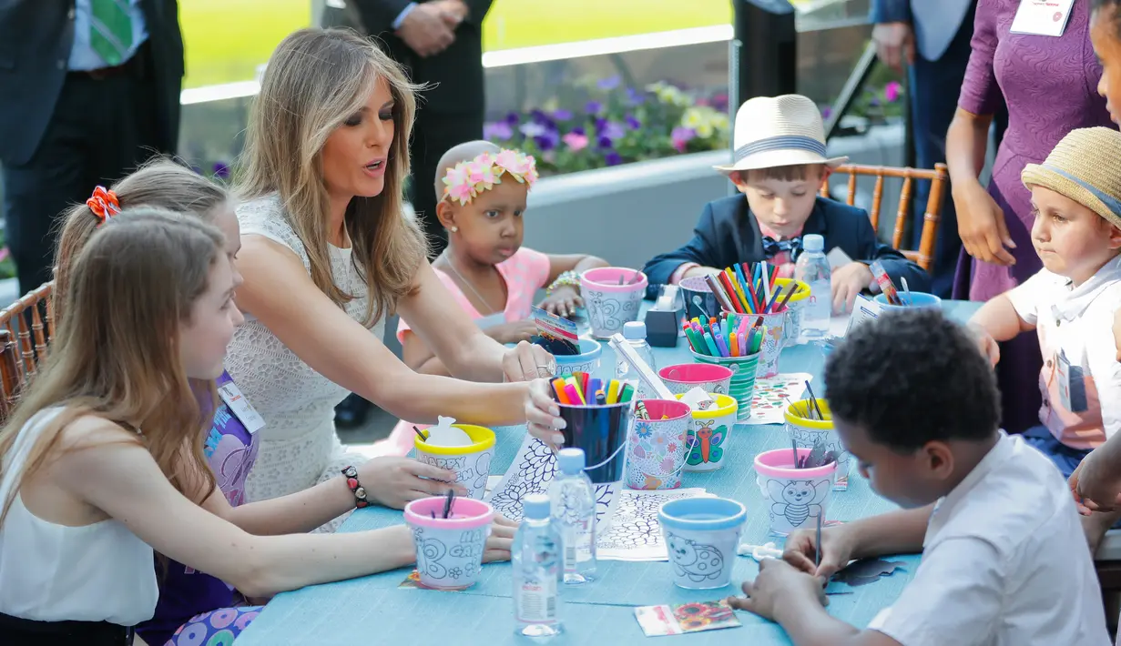 Melania Trump berbincang dengan anak-anak yang sedang mewarnai gambar saat pembukaan Taman Bunny Mellon Healing Garden Bunny Mellon di Rumah Sakit Nasional Anak di Washington, (29/4). (AP Photo/Pablo Martinez Monsivais)