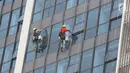 Pekerja membersihkan kaca gedung bertingkat di Jakarta, Kamis (18/10). Kepala Divisi Komunikasi BPJS Ketenagakerjaan Irvansyah Utoh Banja mengatakan, BPJS Ketenagakerjaan menargetkan kepesertaan BPJS Ketenagakerjaan 2018. (Liputan6.com/Immanuel Antonius)