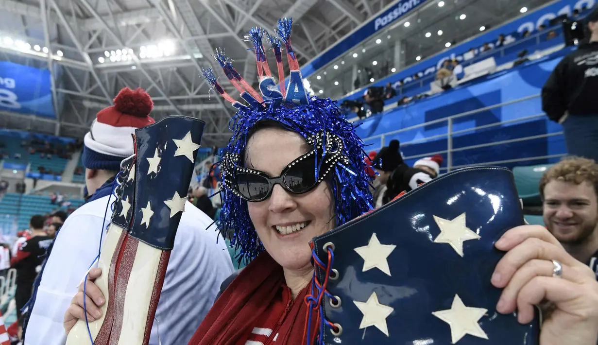 Fans wanita AS memakai atribut unik saat menyaksikan pertandingan hoki es wanita antara Amerika Serikat dan Kanada saat Olimpiade Musim Dingin Pyeongchang 2018 di Gangneung Hockey Center di Gangneung  (22/2). (AFP Photo/Jung Yeon-Je)