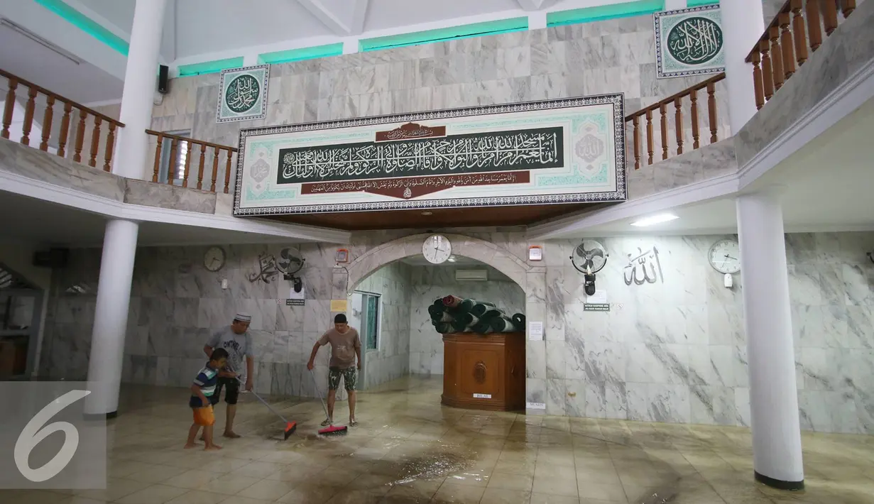 Warga bergotong royong membersihkan banjir yang menggenangi Mesjid An Nur di kawasan Pasar Minggu, Jakarta, Selasa (4/10). Banjir yang rutin menggenangi kawasan tersebut menyebabkan aktivitas warga serta ibadah terganggu. (Liputan6.com/Immanuel Antonius)