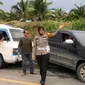Kasat Lantas Kampar AKP Viola Dwi Anggraeni berusaha mengurai kemacetan di jalan lintas Kabupaten Kampar. (Liputan6.com/M Syukur)