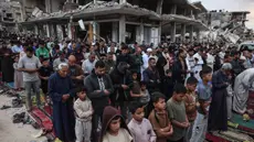 Warga Palestina melaksanakan salat menandai dimulainya Idul Adha, Hari Raya Kurban, di jalan yang rusak parah di Khan Yunis, Jalur Gaza Selatan, pada Rabu 27 Mei 2026. (BASHAR TALEB/AFP)
