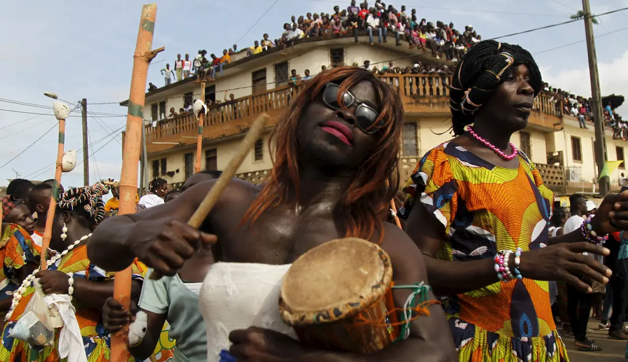 Pria berpakaian wanita saat mengambil bagian dari parade Popo (topeng) dalam karnaval Bonoua , di timur Abidjan, Pantai Gading, (9/4). (REUTERS / Luc Gnago)