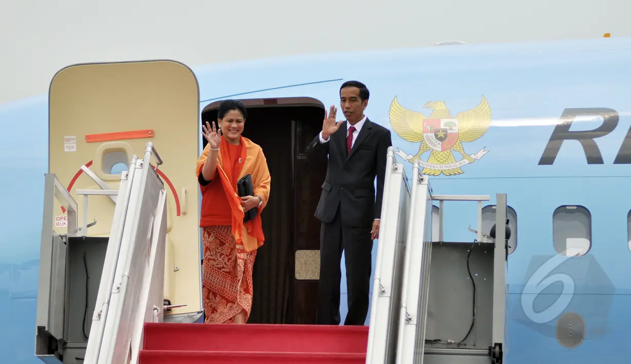 Presiden Jokowi (kanan) dan Ibu Negara, Iriana melambaikan tangan sebelum bertolak memulai kunjungan kenegaraan dengan pesawat kepresidenan di Bandara Halim Perdanakusuma, Jakarta, Minggu (22/3/2015). (Liputan6.com/Faizal Fanani)