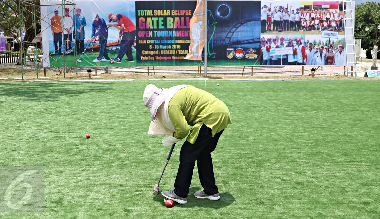 Seorang wisatawan bermain olahraga gateball di Pantai Talise, Palu, Sulawesi Tengah, Selasa (8/3). Event olahraga itu diadakan untuk memeriahkan acara melihat Gerhana Matahari Total bersama yang akan diadakan Rabu (9/3). (Liputan6.com/Immanuel Antonius)