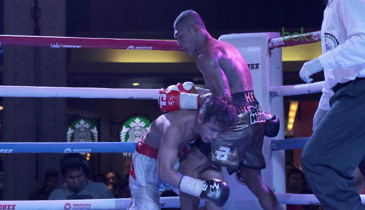 Petinju Indonesia, Jansen Marapu (kanan) menjatuhkan petinju Thailand, Phuttiphong Rakoon pada kelas Lightweight Mahkota Boxing Super Series di Cilandak Town Square, Jakarta (10/3/2018). Jansen menang TKO pada ronde ke sembilan. (Bola.com/Nick Hanoatubun)
