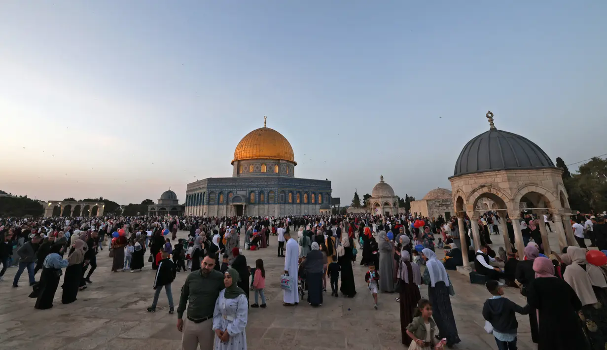 <p>Umat ​​Muslim berfoto di depan masjid Kubah Batu setelah sholat Idul Fitri, yang menandai akhir bulan suci Ramadhan, di kompleks masjid Al-Aqsa di Yerusalem Lama pada 2 Mei 2022. (AFP/Ahmad Gharabli)</p>