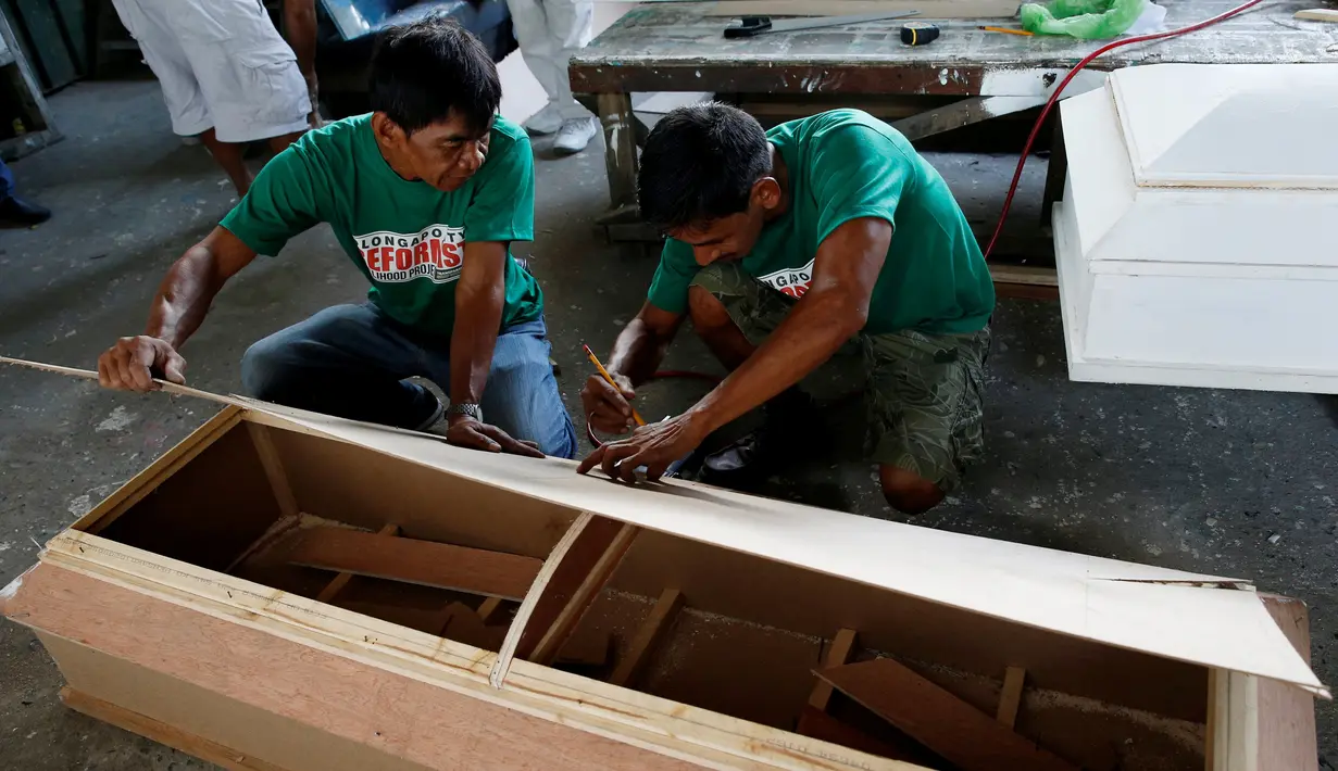  Mantan pengguna narkoba mengukur peti mati di kota Olongapo, Filipina utara, (5/10). Kegiatan ini merupakan bagian dari program rehabilitasi pemerintah setempat bagi mereka yang terjerumus dalam penyalahgunaan narkoba. (REUTERS/Erik De Castro)
