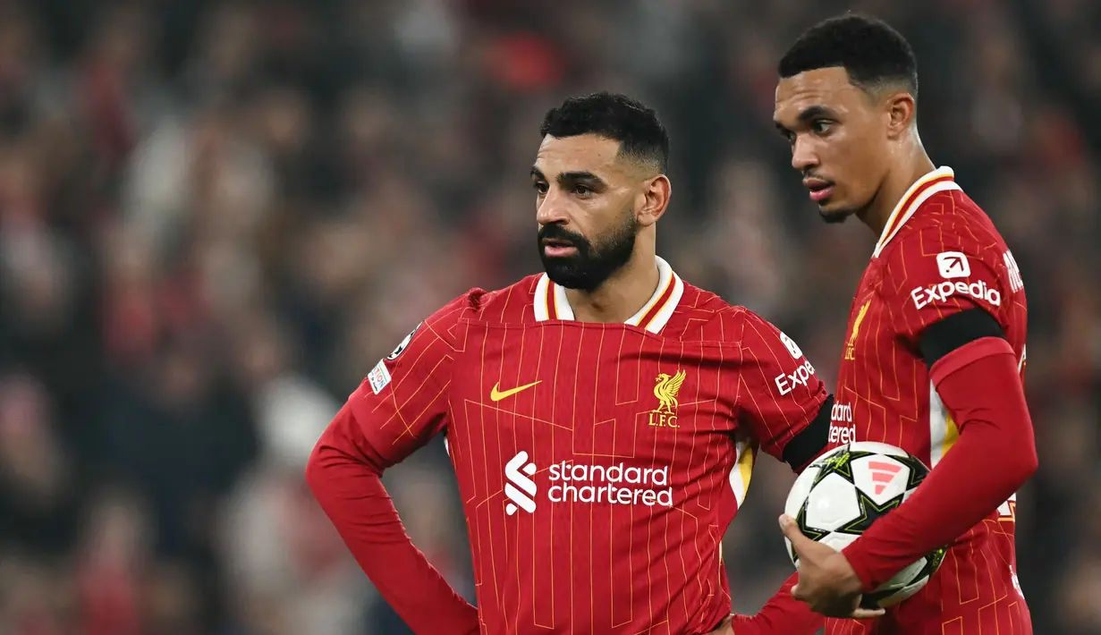 Pemain Liverpool, Mohamed Salah (kiri) berbincang dengan rekannya, Trent Alexander-Arnold saat laga lanjutan Liga Inggris 2024/2025 melawan Aston Villa yang berlangsung di Anfield, Liverpool, Inggris, Minggu (10/11/2024) WIB. (AFP/Paul Ellis)