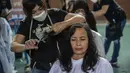 Warga saat potong rambut gratis di Masjid Muhammad Cheng Hoo, Surabaya, Jawa Timur, Senin (18/4/2022). Kegiatan berbagi dalam bulan Ramadhan yang digelar Baksose Suroboyo dan Ngaji Komunitas Salon (Ngasal) Surabaya itu diikuti sekitar 450 orang. (AFP/Juni Kriswanto)