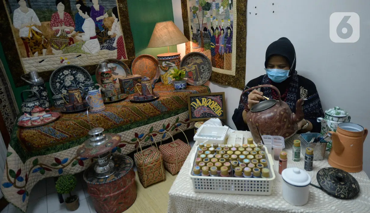 Perajin batik lukis ketel Nova Muhidir menyelesaikan lukisan batik di Studio Daroolang, Bintara, Tangerang Selatan, Banten, Rabu (2/12/2020). Lukisan ketel batik jadul khas nusantara di teko tempat air minum tersebut dijual dengan harga Rp 150 ribu hingga Rp 2,5 juta. (merdeka.com/Dwi Narwoko)