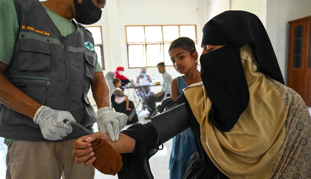 Seorang pengungsi Rohingya mandi di tempat penampungan sementara di Ladong, provinsi Aceh, Jumat 24 Februari 2023. Sedikitnya 69 pengungsi Rohingya mendarat di pantai barat Indonesia pada 16 Februari lalu dengan sebuah perahu kayu. (CHAIDEER MAHYUDDIN/AFP)