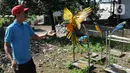 Pelatih Burung Paruh Bengkok Albi (30) melatih burung Blue and Gold Macaw (Ara Ararauna) di sekolah burung miliknya di Cipayung, Depok, Jawa Barat, Selasa (24/5/2022). Untuk biaya pelatihan burung jenis paruh bengkok ukuran Medium 500-2,5 juta dan Large 3- 15 juta rupiah. (merdeka.com/Arie Basuki)