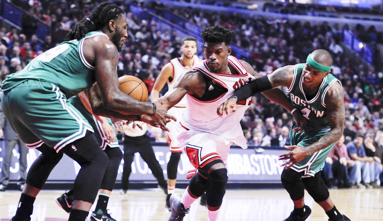 Pemain Chicago Bulls, Jimmy Butler (tengah) dihadang dua pemain Boston Celtics pada laga NBA di United Center, Chicago, Jumat (28/10/2016) WIB. (AP/Matt Marton)