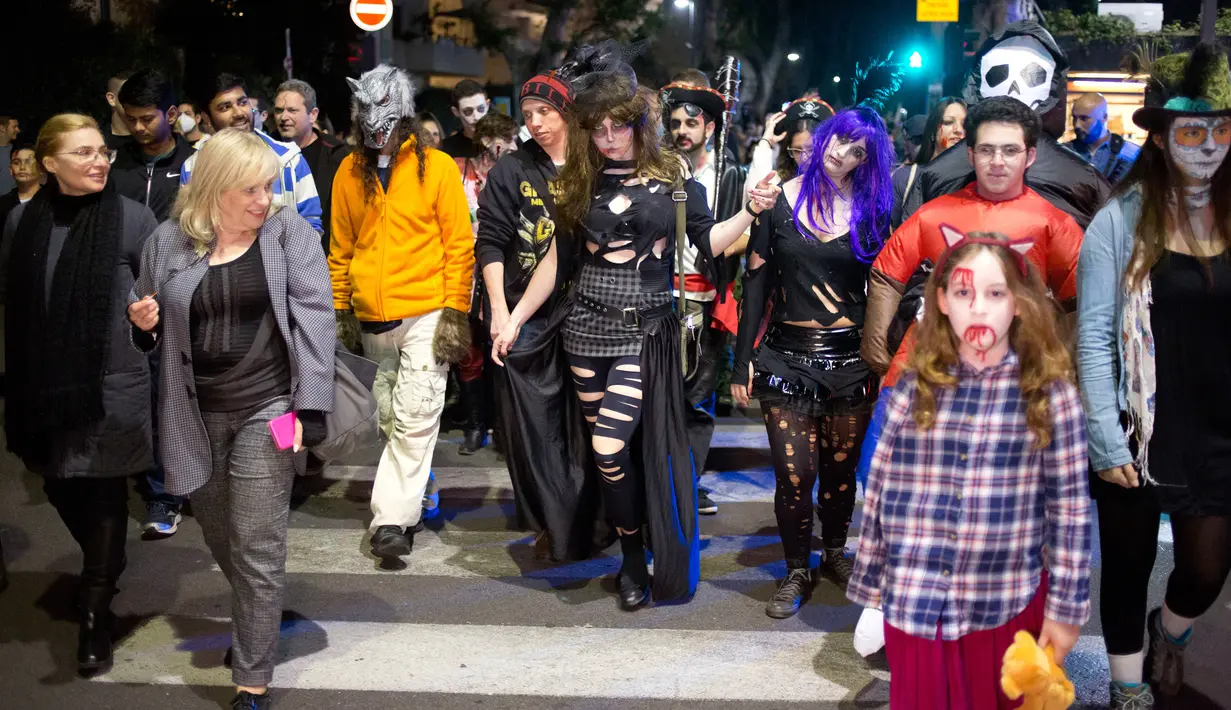 Sejumlah orang turun ke jalan dengan mengenakan kostum zombie saat mengikuti Zombie Walk dalam Festival Purim di Tel Aviv, Israel (3/3). Liburan Purim ini dirayakan dengan parade dan pesta kostum. (AP Photo/Ariel Schalit)