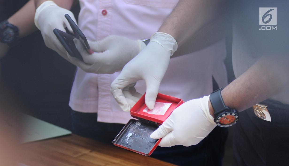 Polisi menunjukkan barang bukti penangkapan artis peran dan model, Jennifer Dunn oleh satuan Dirnarkoba Polda Metro Jaya, Jakarta, Selasa (2/1). Polisi menyita 0,6 gram sabu dan sejumlah telepon genggam. (Liputan6.com/Helmi Fithriansyah)